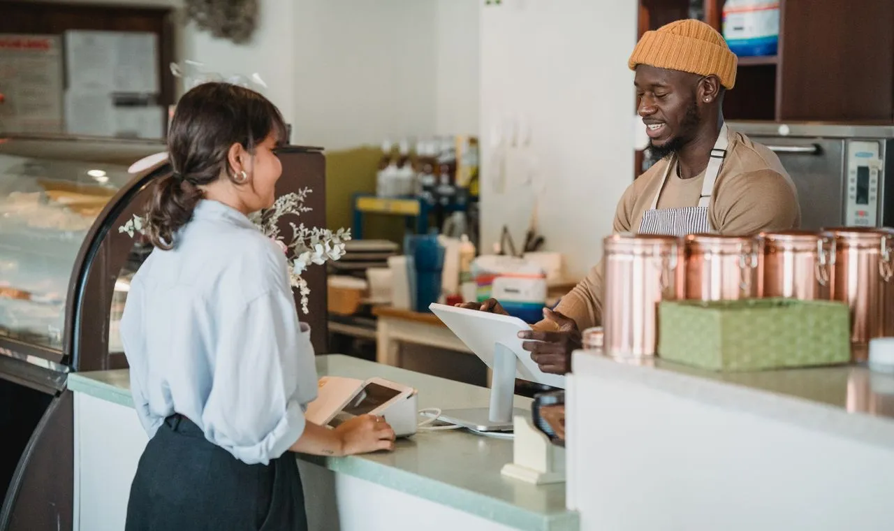 Commerçante accueillant une cliente dans sa boutique — les entreprises guadeloupéennes accompagnées par l'agence web NEWP